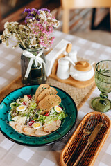 Caesar salad on a blue plate containing cherry tomatoes, grated parmesan