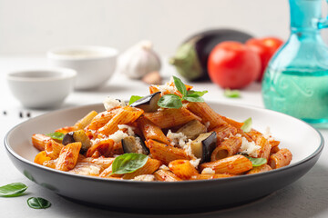 Pasta alla Norma. Traditional Italian dish with eggplant, tomato sauce, ricotta cheese and basil in...