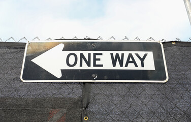 one-way sign on a city street, symbolizing direction, restriction, and adherence to a predefined...
