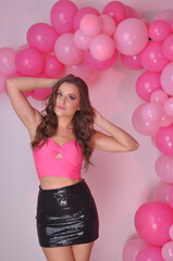beldade linda mulher com top e maquiagem rosa , fundo com balões de festa rosa 
