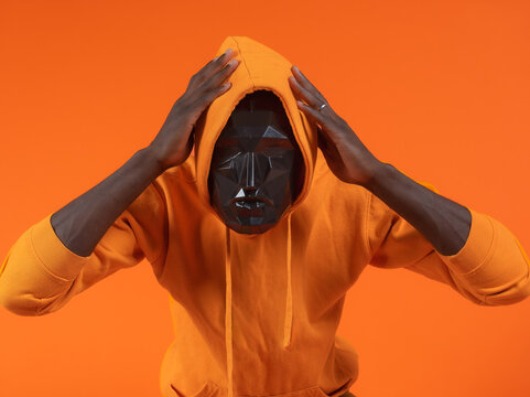 Black man in black blurry face mask and hoodie