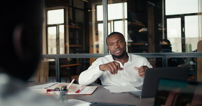 POV view of two businessmen with black skin in white shirts are talking about a new business in the office at the factory