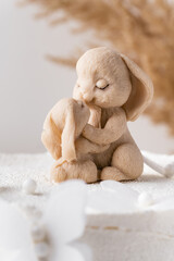 Birthday cake with white cream cheese frosting decorated with .bunny mother and kid chocolate figure on wooden stand. Little baby rabbit hugs its mother. Baby born celebration. Parents love concept