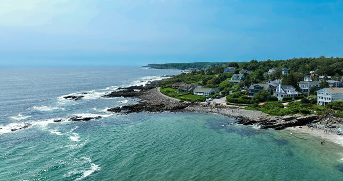 Maine rocky coast with crashing waves and aerial view of marginal way running and walking path.