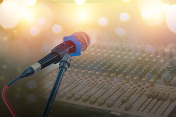 Microphone on blurred background and sound mixer equipment.