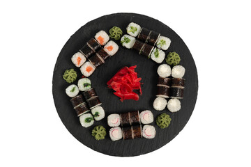 sushi set. different types of sushi on a big round black dish. Sushi set on a black slate.