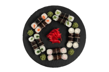 sushi set. different types of sushi on a big round black dish. Sushi set on a black slate.
