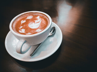 Cup with coffee on white background. Latte art of heart design on coffee. Top view.