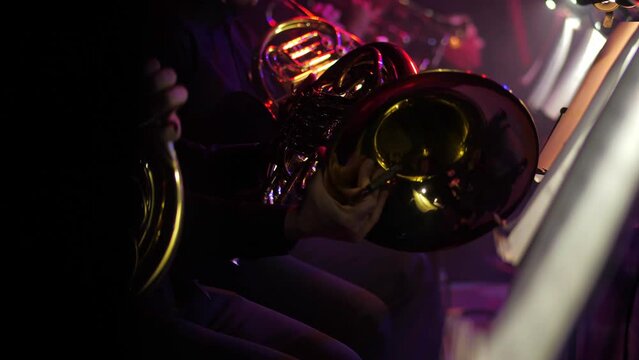 Musical instruments close-up, participants playing wind instruments on stage during a live concert in a large hall. classical music concert or rehearsal.musical ensemble of wind instruments