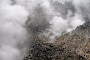 Fototapeta na wymiar Wisps of smoke around the crater scattered rocks