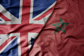 big waving national colorful flag of great britain and national flag of morocco .