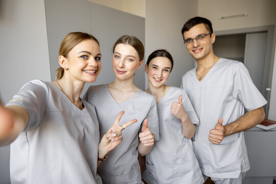 Young team of nurses making selfie photo, while standing together in medical ward. Portrait of cheerful nurses in clinic