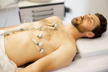 Obraz na płótnie Canvas Patient with suction cup contacts on his chest during a cardiogram in the clinic