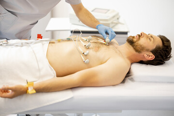 Obraz na płótnie Canvas Patient with suction cup contacts on his chest during a cardiogram in the clinic