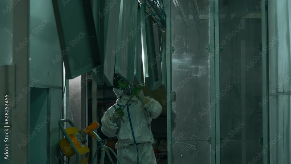 Poster worker at a factory moving a line of metal sheets. creative. man in suit using a steel stick to push