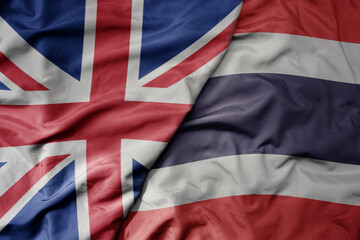 big waving national colorful flag of great britain and national flag of thailand .
