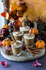Pumpkin spice chia puddings surrounded by autumn decorations.