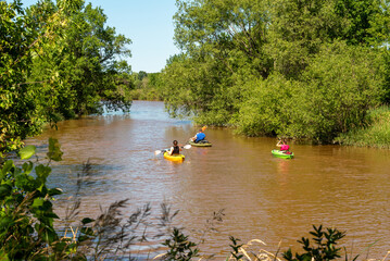 Fototapeta na wymiar Kayakers paddling on the river in summer