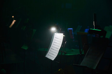 Illumination of the music stand with notes on the stage. Before a concert or orchestra rehearsal