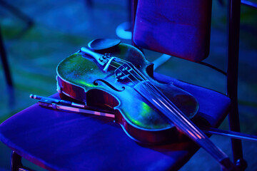 A violin or viola on a musician's chair. Before a concert or orchestra rehearsal