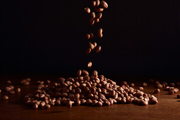 Grãos de amendoim caindo em fundo preto