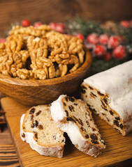 Christmas stollen on wooden background. Traditional Christmas festive pastry dessert. Holiday concept. Dessert, cake, pie with marzipan, nuts and dried fruits. Stollen for Christmas. Spicy pastries.