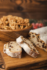 Christmas stollen on wooden background. Traditional Christmas festive pastry dessert. Holiday concept. Dessert, cake, pie with marzipan, nuts and dried fruits. Stollen for Christmas. Spicy pastries.