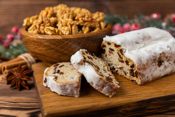 Christmas stollen on wooden background. Traditional Christmas festive pastry dessert. Holiday concept. Dessert, cake, pie with marzipan, nuts and dried fruits. Stollen for Christmas. Spicy pastries.