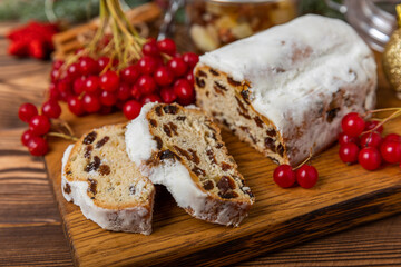 Christmas stollen on wooden background. Traditional Christmas festive pastry dessert. Holiday concept. Dessert, cake, pie with marzipan, nuts and dried fruits. Stollen for Christmas. Spicy pastries.