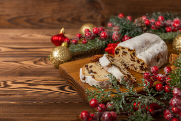 Christmas stollen on wooden background. Traditional Christmas festive pastry dessert. Holiday concept. Dessert, cake, pie with marzipan, nuts and dried fruits. Stollen for Christmas. Spicy pastries.