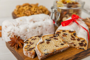 Fototapeta na wymiar Christmas stollen on wooden background. Traditional Christmas festive pastry dessert. Holiday concept. Dessert, cake, pie with marzipan, nuts and dried fruits. Stollen for Christmas. Spicy pastries.