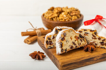 Christmas stollen on wooden background. Traditional Christmas festive pastry dessert. Holiday concept. Dessert, cake, pie with marzipan, nuts and dried fruits. Stollen for Christmas. Spicy pastries.