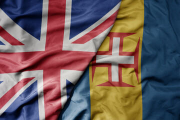 big waving national colorful flag of great britain and national flag of madeira .