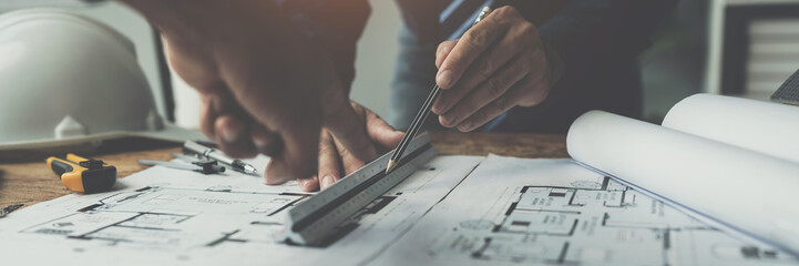 Team of engineers reviewing blueprints Sketch of a new construction project with engineering tools at office desk. For improvement of house designs in mortgage, rent, sale, real estate