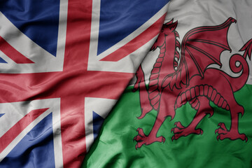 big waving national colorful flag of great britain and national flag of wales .
