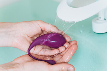 Hands washing vibro vaginal and anal massager Egg - obrazy, fototapety, plakaty