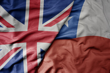 big waving national colorful flag of great britain and national flag of chile .