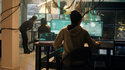 Anonymous hackers trying to break into government server, using espionage concept to ask for ransom, people performing hacktivism. Spies stealing data to exploit cyberbullying. Handheld shot.
