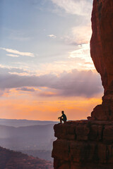 Silhouette of man on the trail at Cathedral Rock at sunset in Sedona. The colourful sunset over...