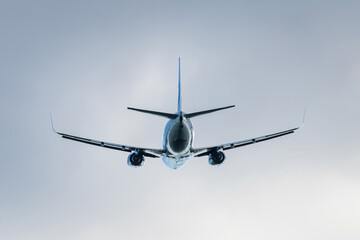 Flying jet passenger plane in the sky, rear view