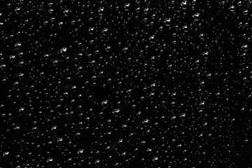 Rain droplets or splashing and floating drop on the black glass at the night, Blurry images of soda...