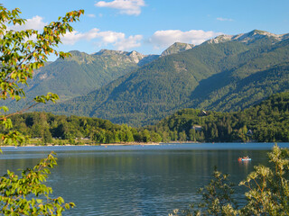 Summer bustle on the shores of a beautiful freshwater lake under high mountains