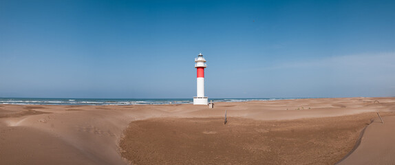 panorama of lighthouse on a sunny day in Punta del Fangar. Ebro Delta.