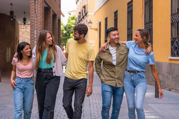 Obraz premium Group of multiracial friends embracing smiling in the city, friendship concept with guys and girls hanging out in the city street