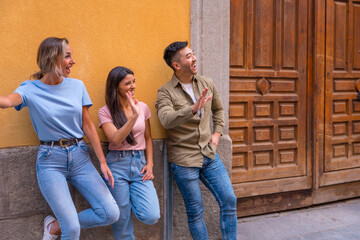 Group of multiracial friends waving in the city, friendship concept with guys and girls hanging out in the city street