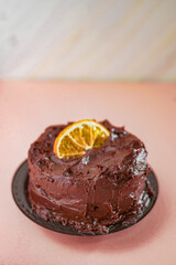 Porción de Pastel de Chocolate con Topping de Fudge y Decoración de Naranja Deshidratada