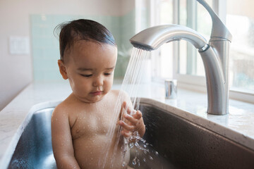 child in the sink bath