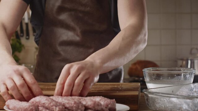 Home chef preparing a BBQ recipe - the Balkan kebapche or cevapcici. Closeup shot. Low angle.