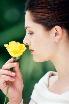  Young woman smelling yellow flower 