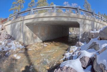 Miller Creek flowing under a bridge at the Thumb Butte Recreation Area in the Prescott National Forest just west of Prescott Arizona, covered in winter snow and ice.